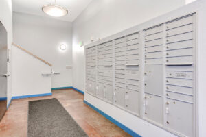 Indoor Cluster mailbox unit, tile floor, hallway.